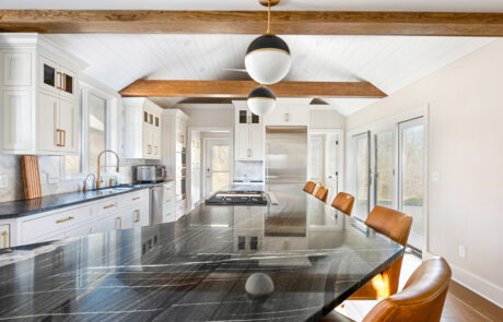 White kitchen island with black marble countertop.