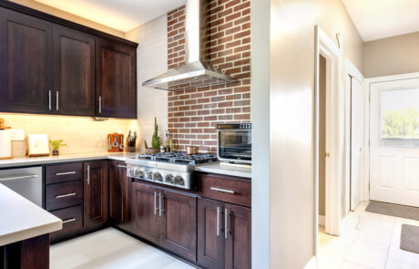 Kitchen renovation with brick behind range and hood.