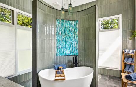 Bathroom renovation featuring a curved wall behind a freestanding oval white tub